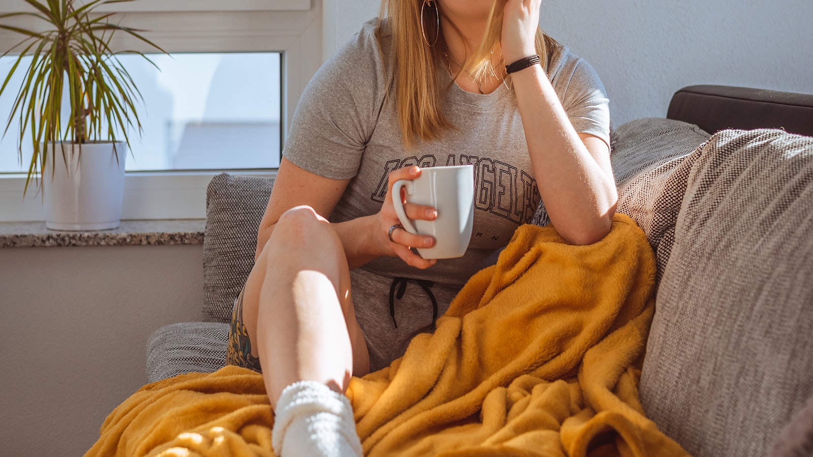 Žena odpočívá na pohovce s hrnkem — Foto: Julian Bock / Unsplash